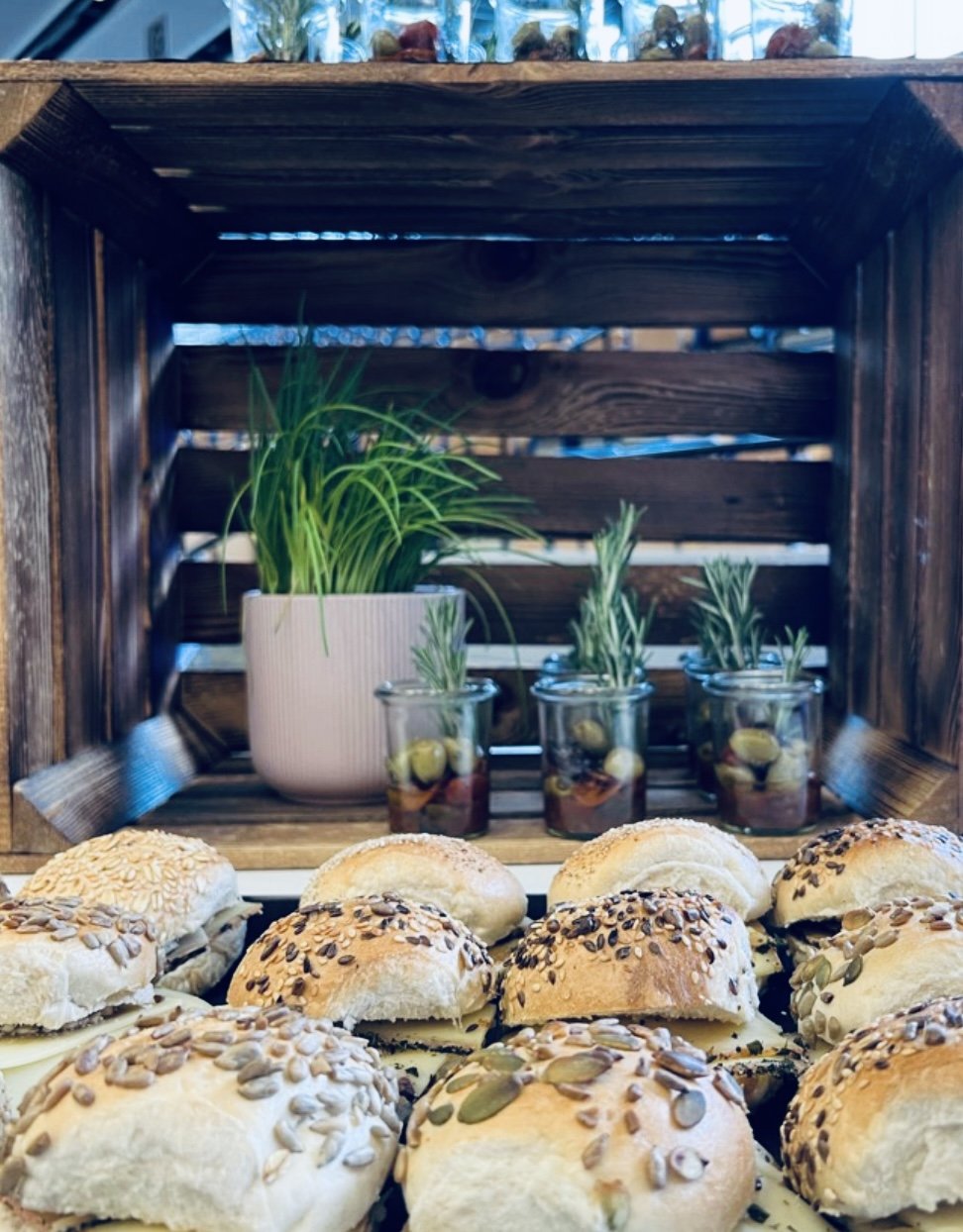 Mini-Slider und Antipasti-Häppchen auf Buffet-Display mit Holz-Boxen